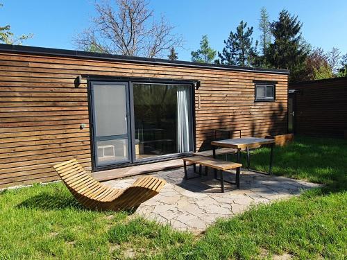 a cabin with a picnic table and a bench in the grass at Lavečka u Valtic in Valtice