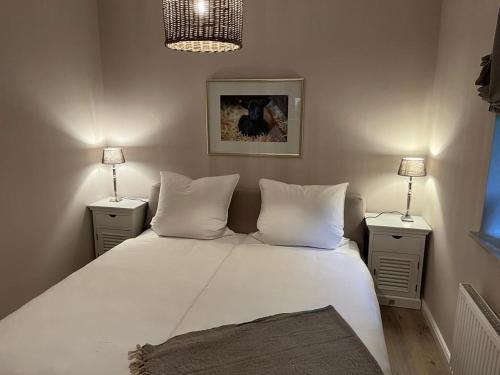 ein Schlafzimmer mit einem großen weißen Bett mit zwei Nachttischen in der Unterkunft Schnuckenhütte in Soltau