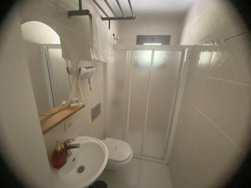 a bathroom with a shower and a toilet and a sink at Zu Tiny House Hotel & Restaurant in Urla