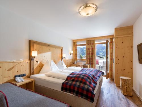 a hotel room with a large bed and a window at Hotel Alpenpanorama in Söll
