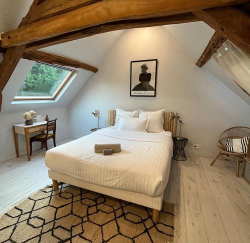um quarto com uma cama grande num sótão em Le Petit Château de Conteville em Paluel