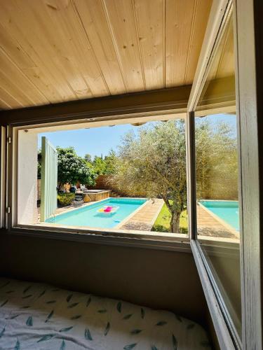 uma janela num quarto com vista para a piscina em Dépendance Tulum em Cabriès