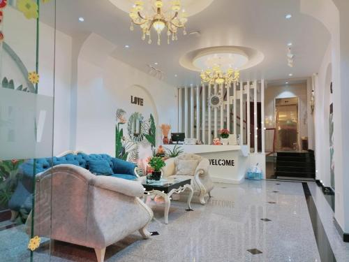 un salon avec un canapé, des chaises et un lustre dans l'établissement WHITE COFFEE HOUSE HOTEL, à Đà Lạt