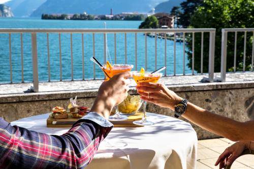 two people sitting at a table with drinks at Hotel Lovere Resort & Spa in Lovere