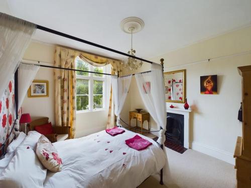 a bedroom with a canopy bed and a fireplace at The Old Vicarage in Ilfracombe