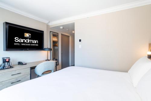 a bedroom with a bed and a tv on a wall at Sandman Hotel Vancouver Downtown in Vancouver