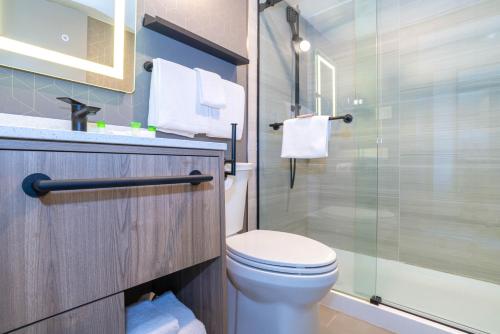 a bathroom with a toilet and a glass shower at Sandman Hotel Vancouver Downtown in Vancouver