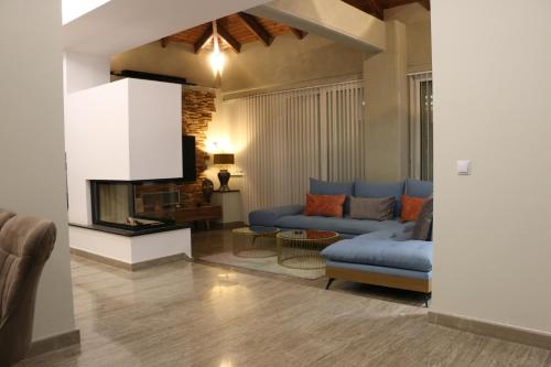 a living room with a blue couch and a fireplace at Exzellent ApartAthens 120qm, near Metro M2 in Athens