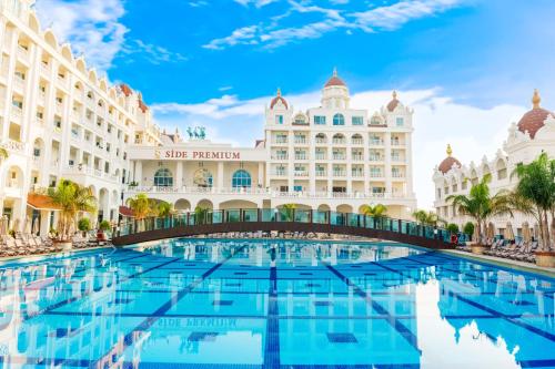 una piscina d'albergo di fronte a un grande edificio di Oz Hotels Side Premium a Side