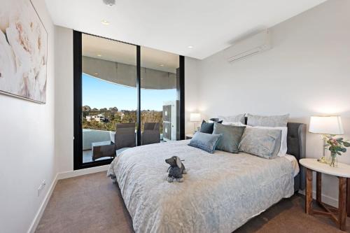 a teddy bear sitting on a bed in a bedroom at Luxury overlooking the Yarra - 01663 in Melbourne