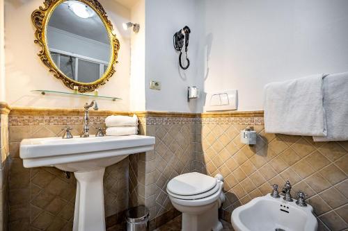 a bathroom with a sink and a toilet and a mirror at Soggiorno Campos in Florence