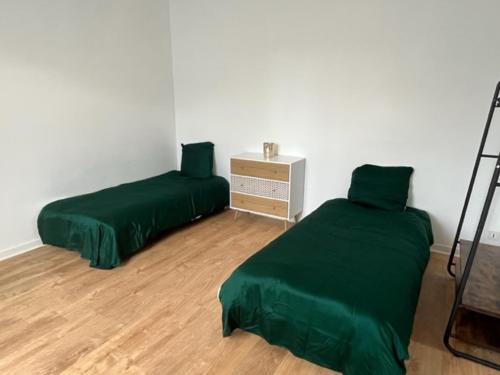 1 dormitorio con 2 camas verdes y suelo de madera en Maison - jardin aux portes de Bordeaux en Cenon