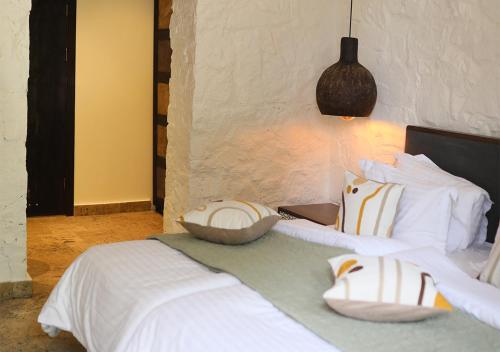 a bedroom with a bed with white sheets and pillows at Toon Armeni Guest House in Dilijan