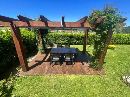 einen Tisch und Stühle unter einer Pergola im Hof in der Unterkunft Casa da Portela in Paredes de Coura