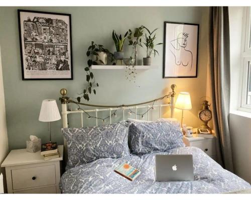 a bedroom with a bed with a laptop on it at Bright, book-filled flat in artsy Stokes Croft in Bristol