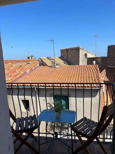 a table and chairs on a balcony with a roof at Appartement le quartier haut in Sète