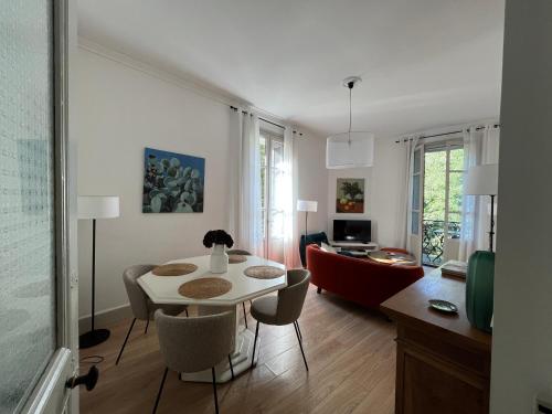 un salon avec une table et des chaises blanches dans l'établissement Nimes , appartement rénové dans immeuble classé., à Nîmes
