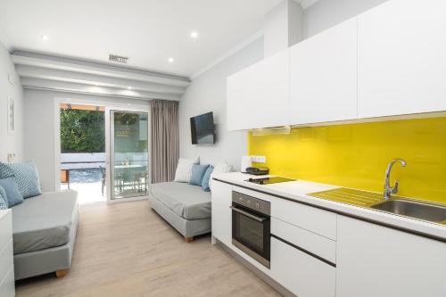 a kitchen with a sink and a living room at Helion Apartments in Gouvia