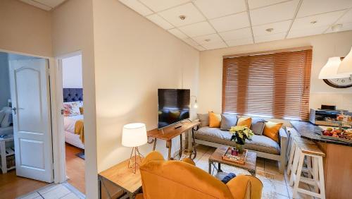 een woonkamer met een bank en een tafel bij The Skinny Expat in Paarl