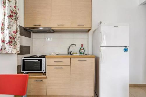 a kitchen with a white refrigerator and a microwave at Papatsas Center Houses in Nydri