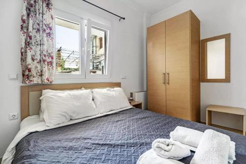 a bedroom with a bed with white pillows and a window at Papatsas Center Houses in Nydri