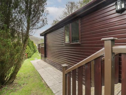 a house with a wooden fence next to it at Canadian Cabin No 39 in Keswick