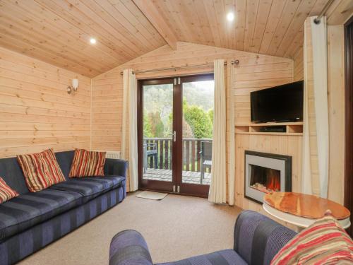 a living room with a couch and a fireplace at Canadian Cabin No 39 in Keswick