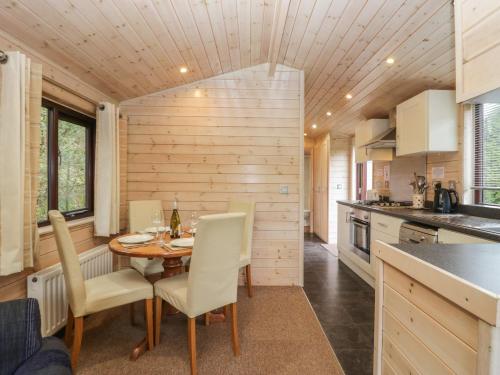 a kitchen and dining room with a table and chairs at Canadian Cabin No 39 in Keswick
