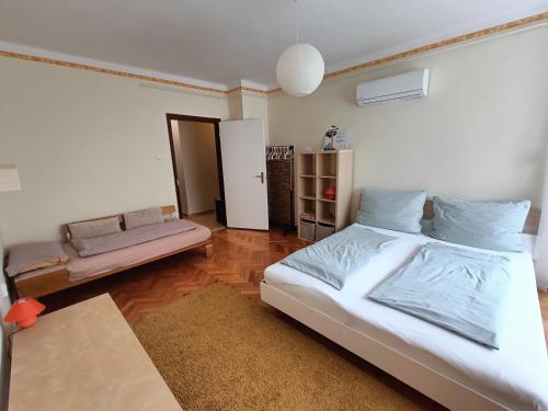 NewIsland Family Apartman في شارفار: غرفة نوم بسرير كبير وأريكة