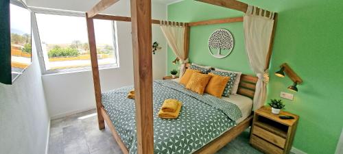 a bedroom with a canopy bed in a green room at Ferienwohnung Vista Faro in Morro Jable in Morro del Jable