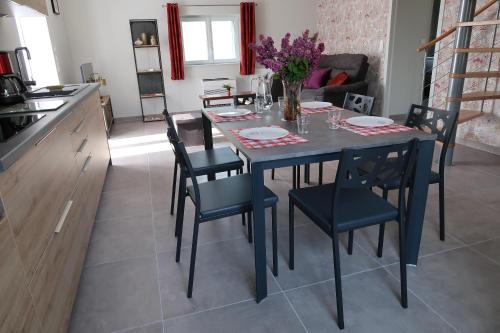 a kitchen and dining room with a table and chairs at Le Sophora in Chéu