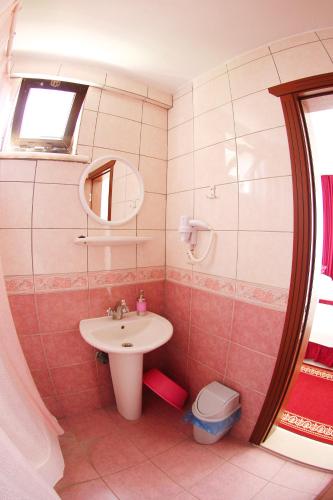 a bathroom with a sink and a mirror and a toilet at Soykan Hotel in Marmaris
