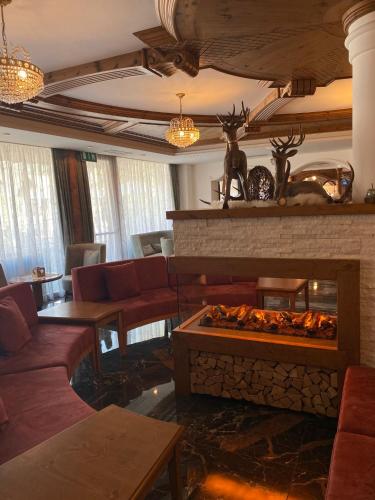 a living room with a fire place in the middle at Family Hotel La Perla in Fiera di Primiero