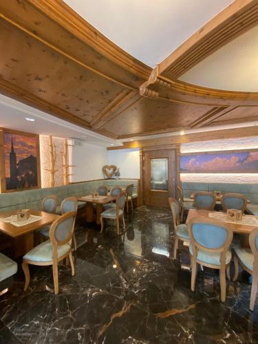 a restaurant with tables and chairs in a room at Family Hotel La Perla in Fiera di Primiero