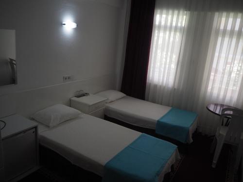 マルマリスにあるSoykan Hotelのベッド2台と窓が備わるホテルルームです。