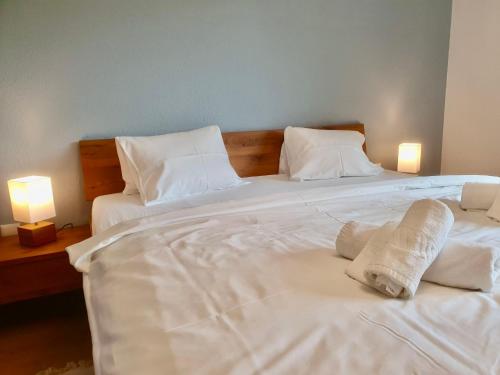 a white bed with towels on it with two lamps at Apartment La Riva by Interhome in Laax