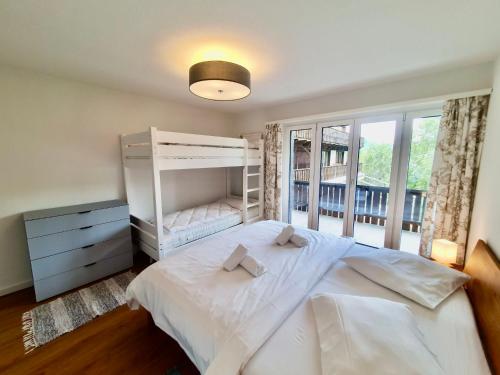 Un dormitorio con una gran cama blanca y una ventana en Apartment La Riva by Interhome, en Laax