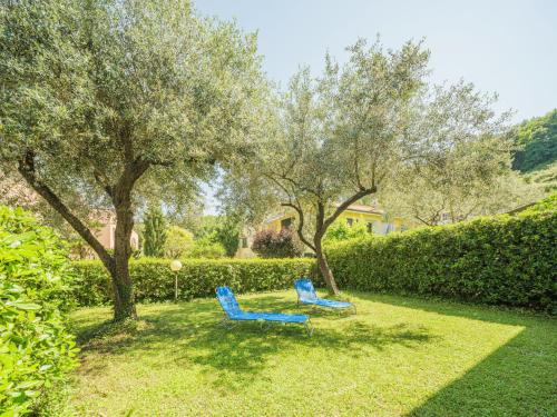 zwei blaue Stühle in einem Garten mit Bäumen in der Unterkunft Holiday Home Lucerna Due-1 by Interhome in Ameglia