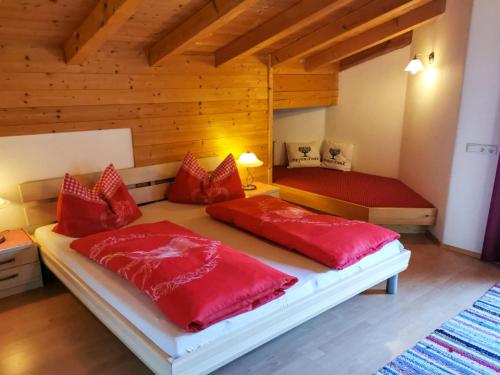 a bedroom with two beds with red pillows at Holiday Home Reichegger by Interhome in Grün