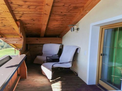 a small porch with two chairs and a window at Holiday Home Reichegger by Interhome in Grün