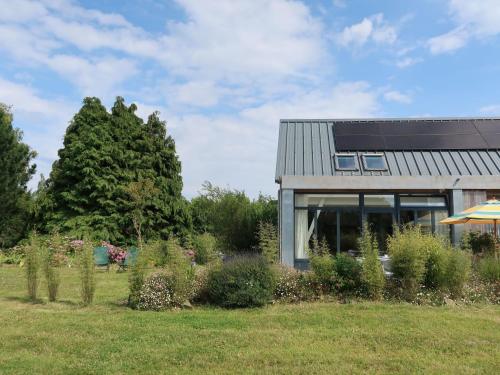 a house in a field with bushes and trees at Chalet L'Atelier by Interhome in Locquirec