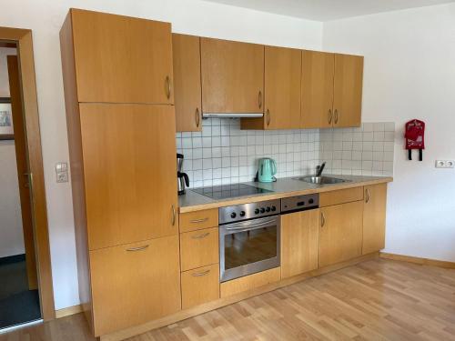 a kitchen with wooden cabinets and a sink and a stove at Apartment Kathrein - ISL505 by Interhome in Ischgl