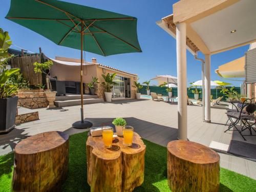 un patio con 2 taburetes de madera con zumo de naranja en Apartment Bela Vista - PMO130 by Interhome en Lagoa