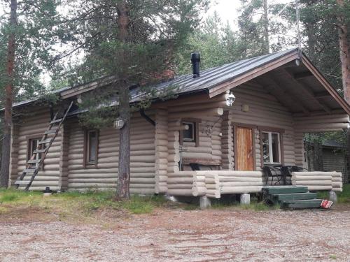 a small log cabin with a porch and a ladder at Holiday Home Saivontupa by Interhome in Ylikyro
