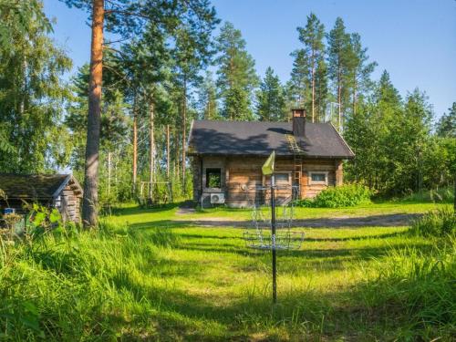 une cabane en rondins dans les bois avec un objectif dans l'établissement Holiday Home Karjalan kelohuvila by Interhome, à Muurasjärvi