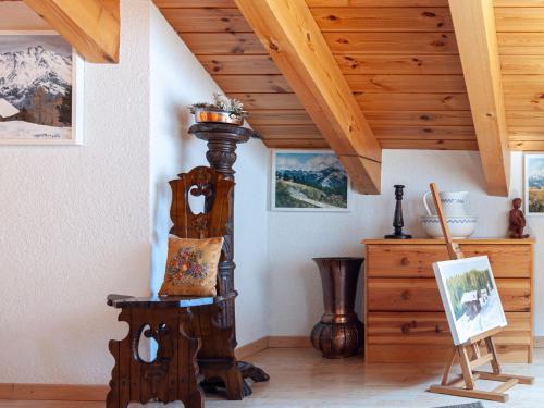 a room with a wooden grandfather clock and a table at Apartment Lake Placid A7 by Interhome in Nendaz