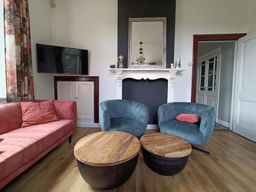 a living room with a couch and two chairs and a table at Cozy Countryside Getaway in De Heurne