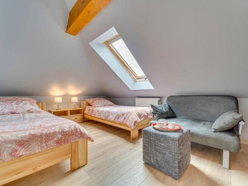 een slaapkamer met 2 bedden, een bank en een raam bij Apartment Kubaczka by Interhome in Wisła