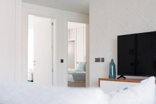 a living room with a television and a bedroom at Orange Boutique Residence - Casa Diogo in Quarteira