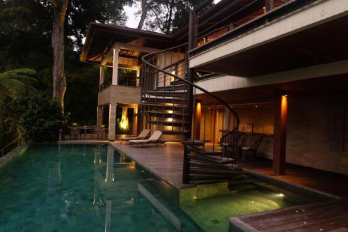 a house with a swimming pool at night at Gana Begawan Luxury Private Villa in Payangan